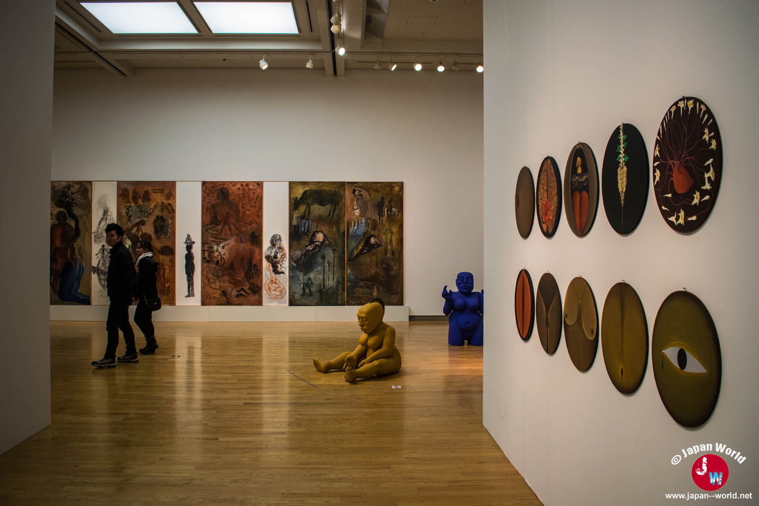 Salle de la galerie permanente avec des œuvres circulaires et des peintures exposées sur les murs