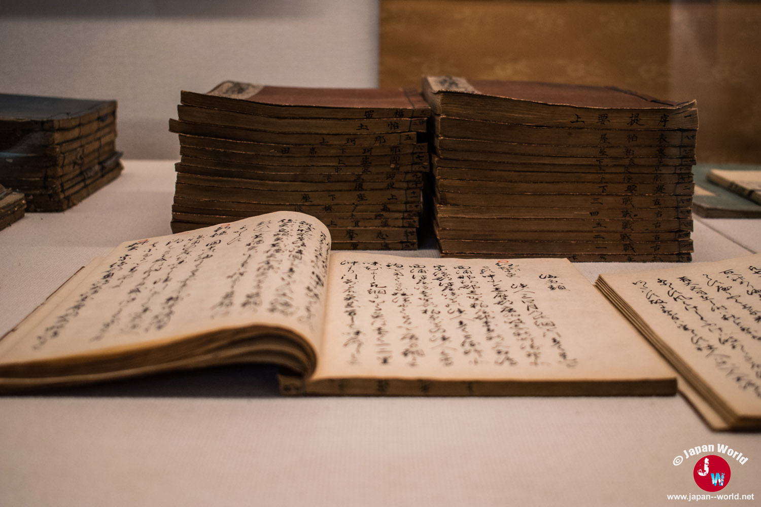 Livres japonais anciens ouverts et empilés dans l'exposition principale