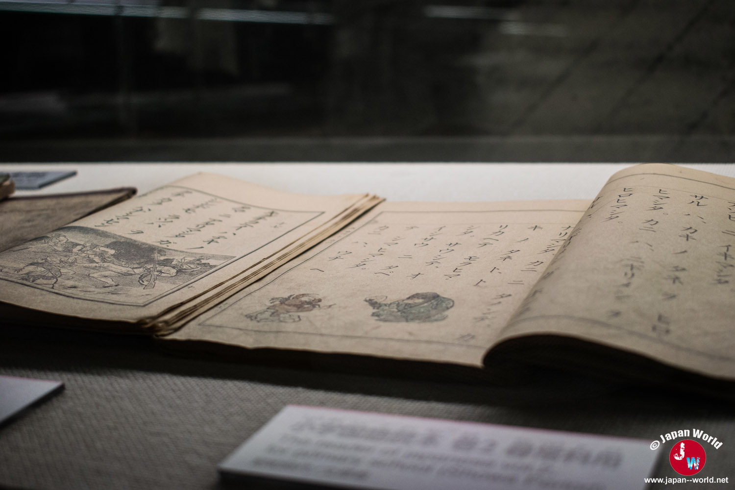 Livre japonais ancien illustré ouvert sous vitrine