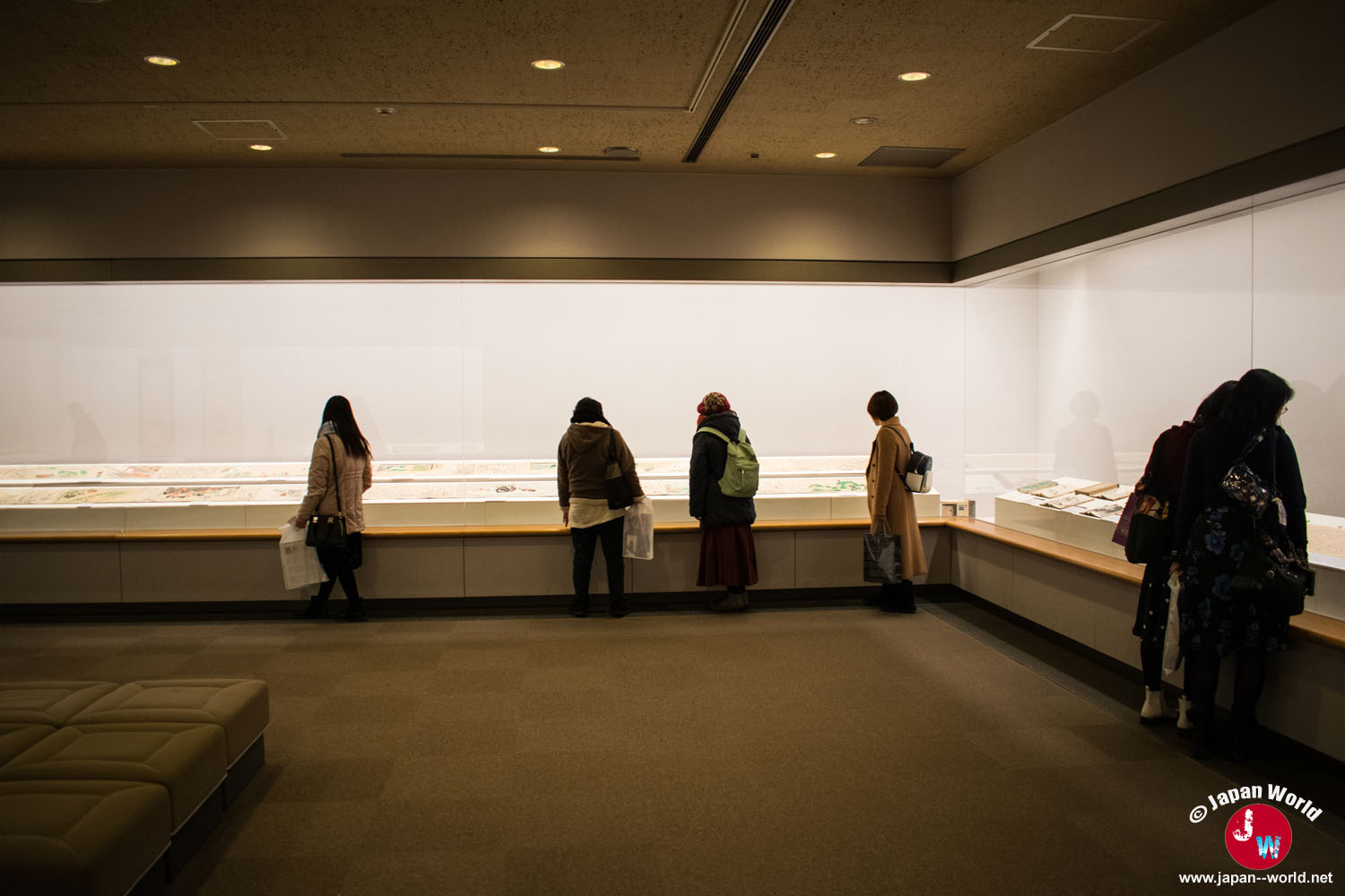 Visiteurs observant les objets présentés dans la première exposition mise en vedette