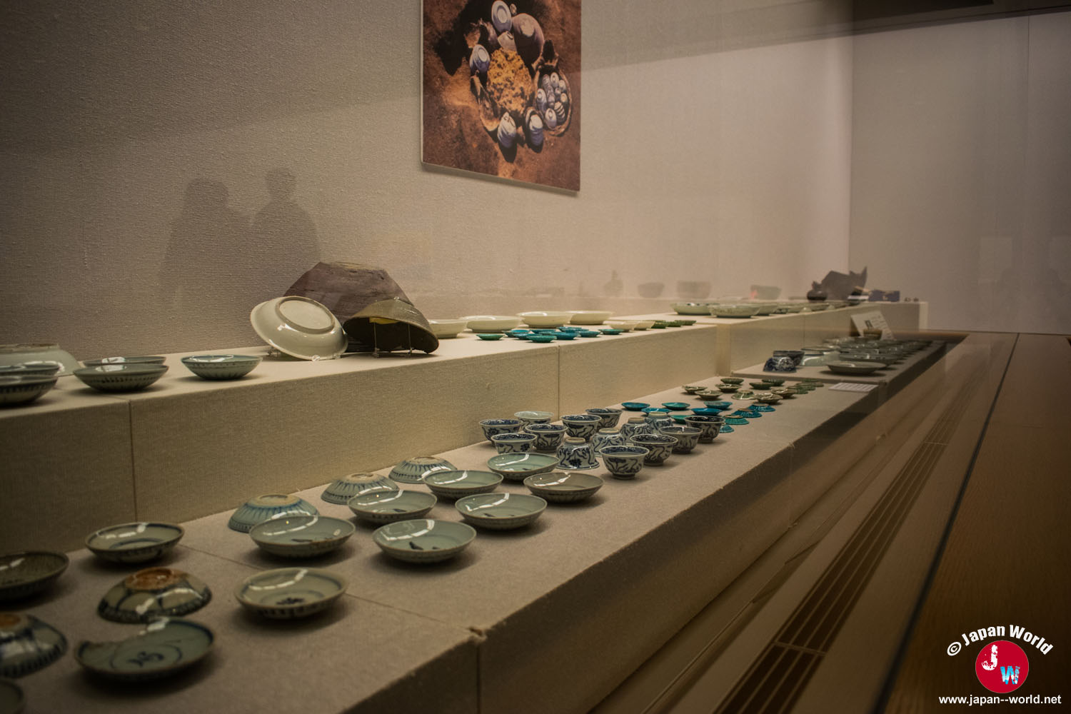 Petites céramiques décorées alignées dans une vitrine du musée