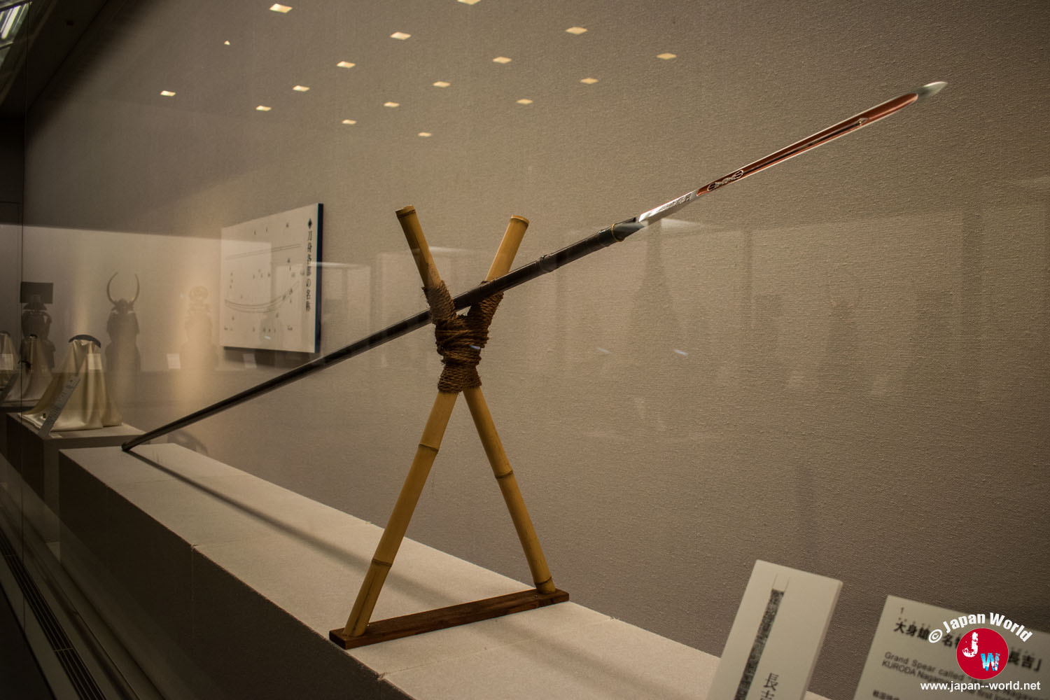 Longue lance japonaise à lame rouge exposée dans la salle des samouraïs