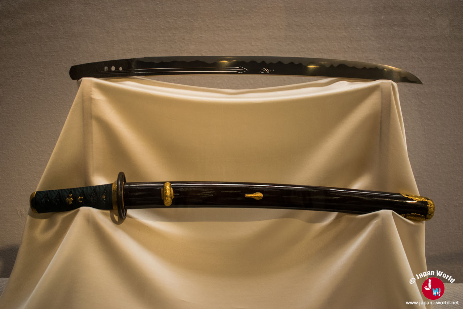 Katana accompagné d'un fourreau noir décoré de motifs dorés