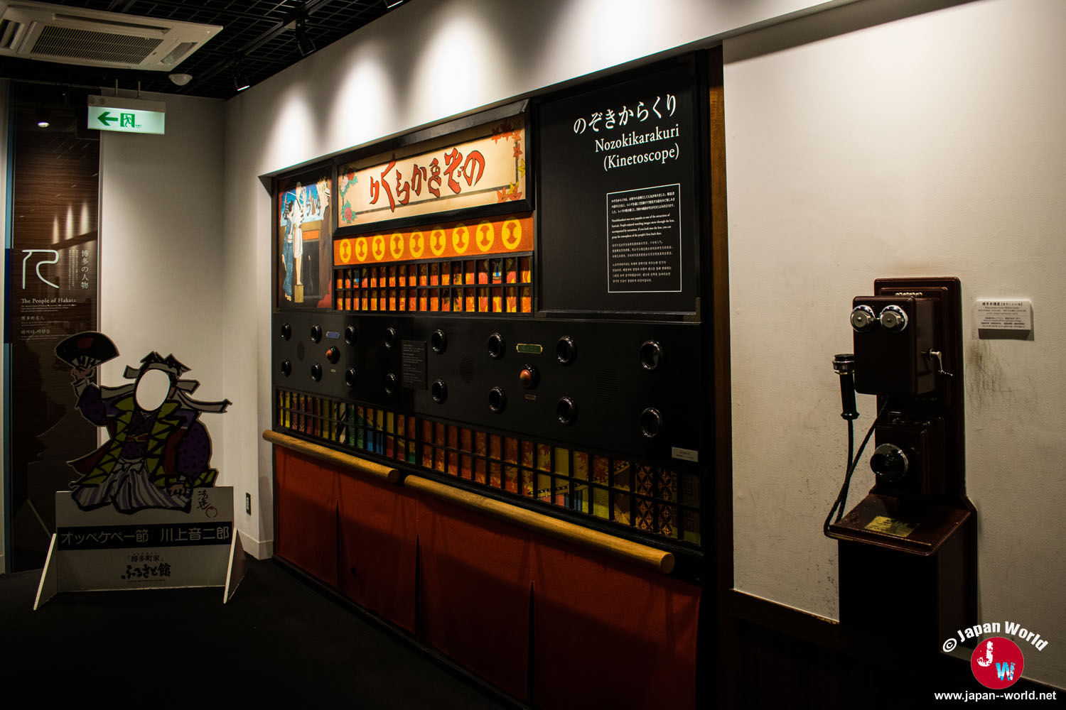 Installation du Nozokikarakuri avec ses images lumineuses et un ancien téléphone