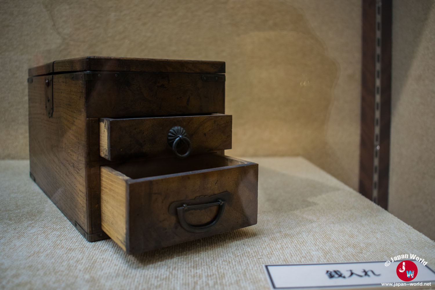 Ancienne boîte à monnaie en bois exposée parmi les objets du commerce à Hakata