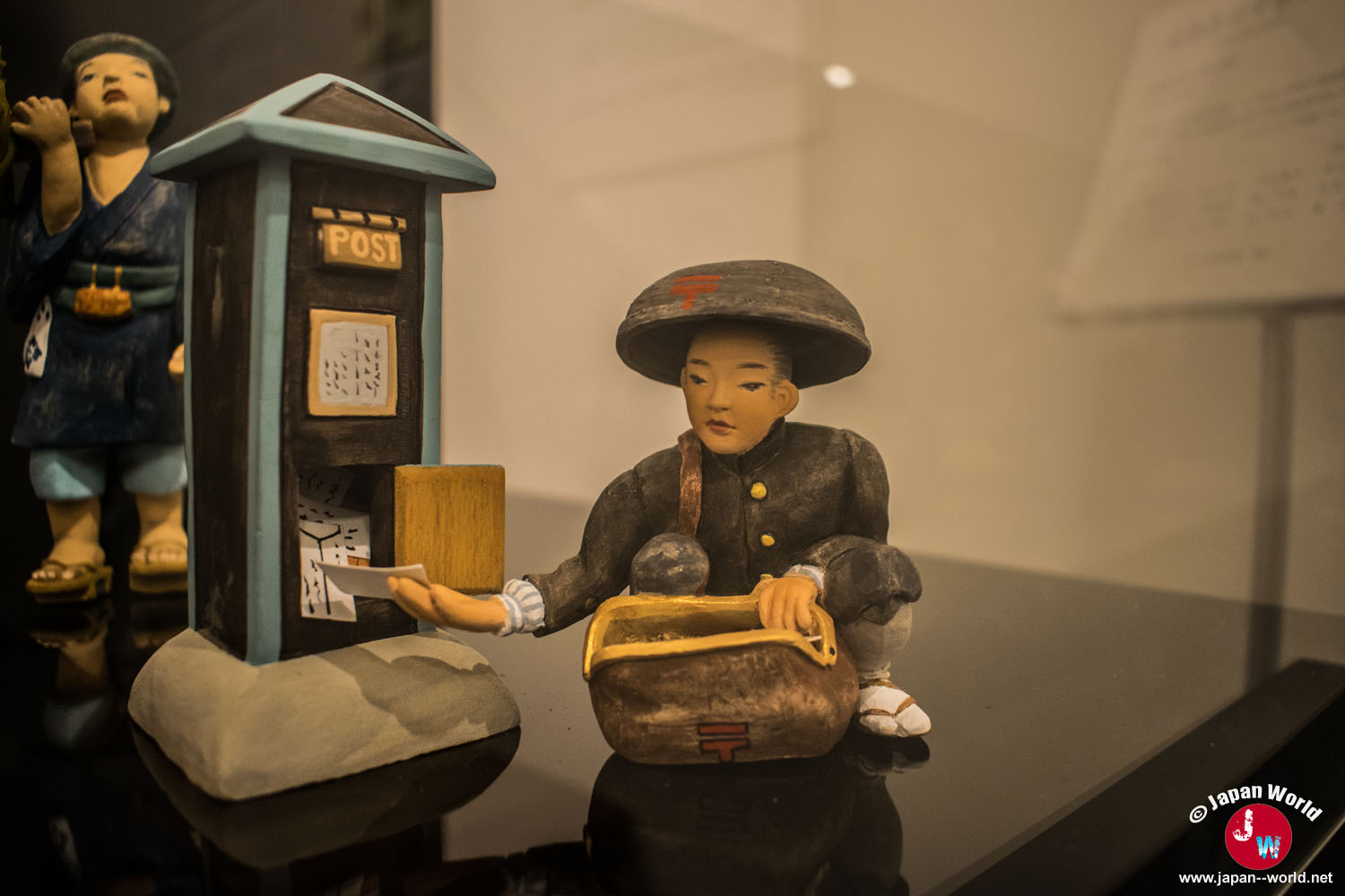 Scène de Hakata Niwaka avec un musicien et un personnage devant une boîte aux lettres