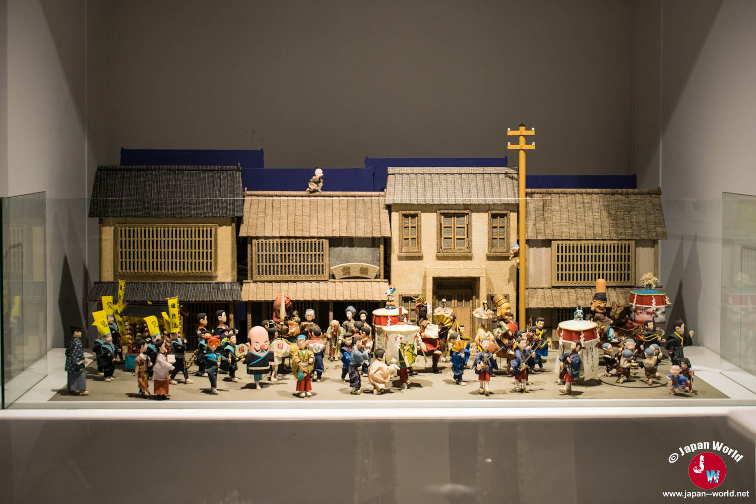Maquette d'une procession traditionnelle dans une rue de Hakata bordée de machiya