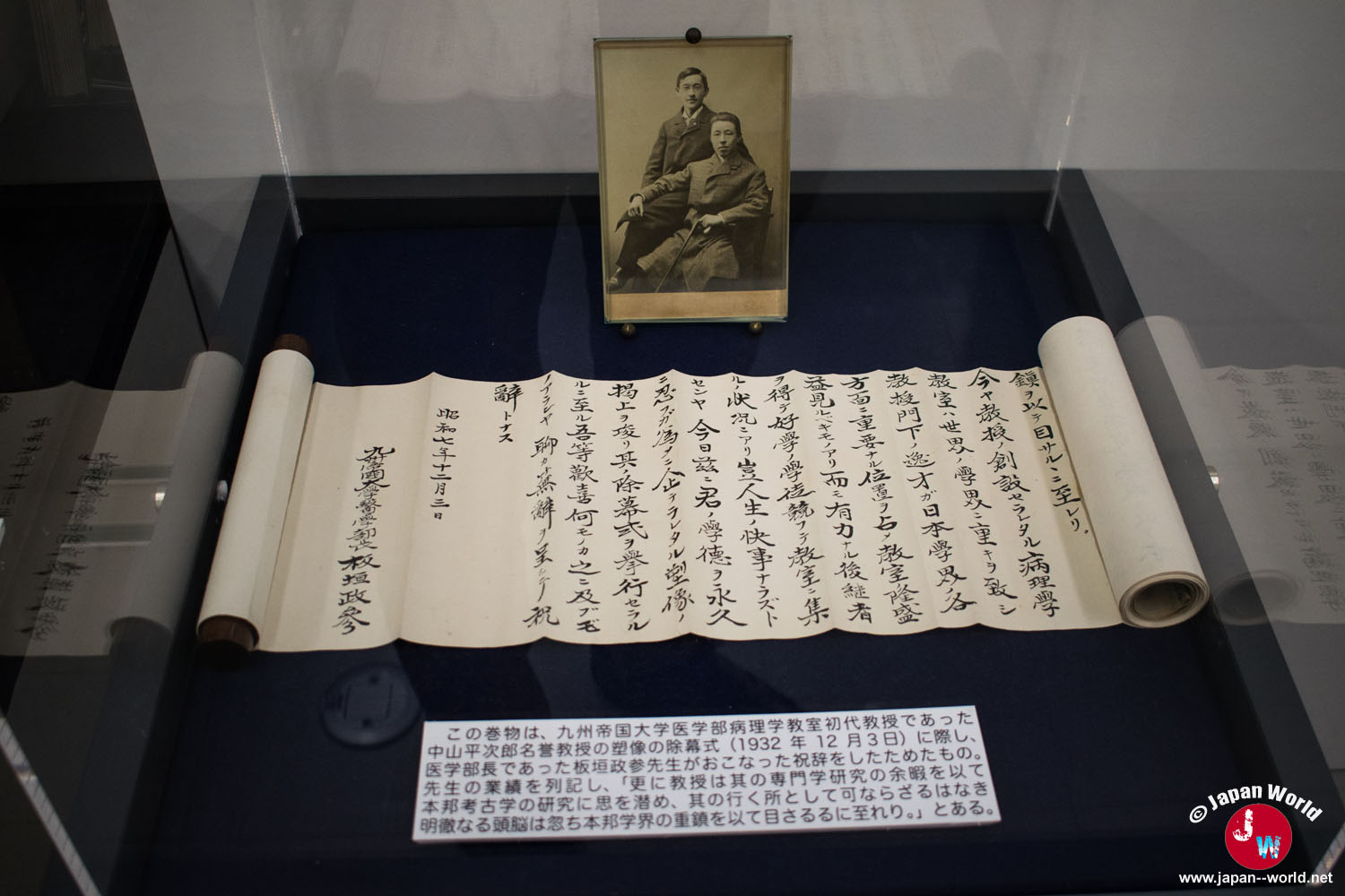 Manuscrit japonais en rouleau exposé sous vitrine avec le portrait de son auteur