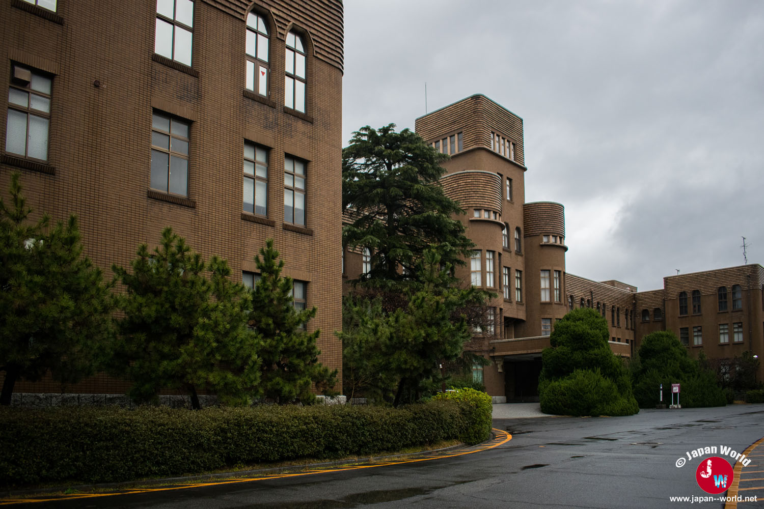 Bâtiments en briques de l'université de Kyushu bordant une allée du campus Hakozaki