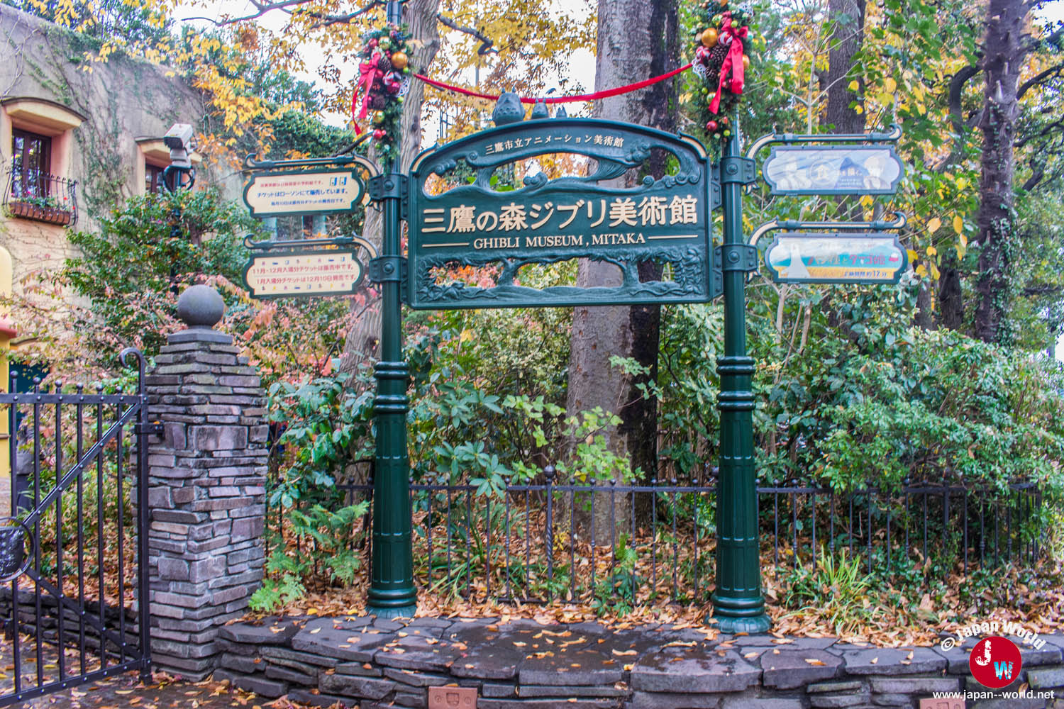 Panneau d'entrée du musée Ghibli entouré de végétation à Mitaka