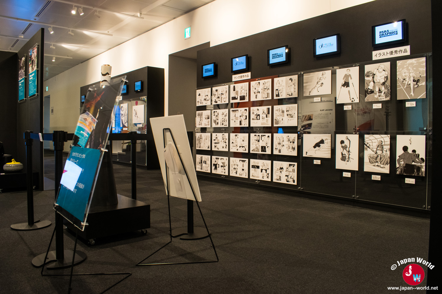 Planches de manga et illustrations de parasports présentées sur un mur de l'exposition