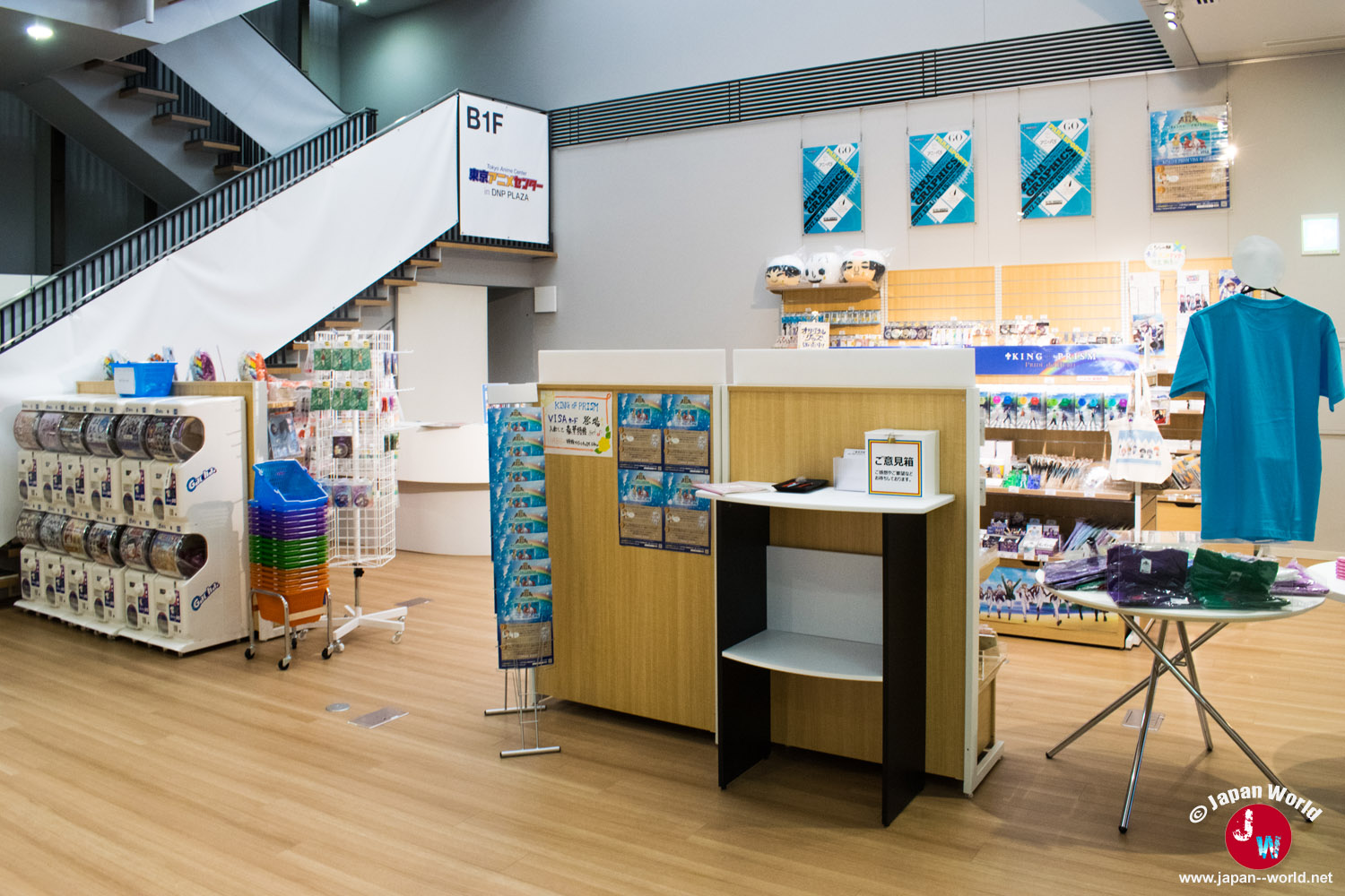 Vue générale de la boutique avec distributeurs à capsules, présentoirs de produits et tee-shirt bleu