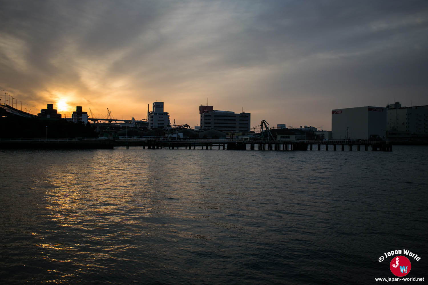 Soleil couchant sur les bâtiments industriels du port de Hakata