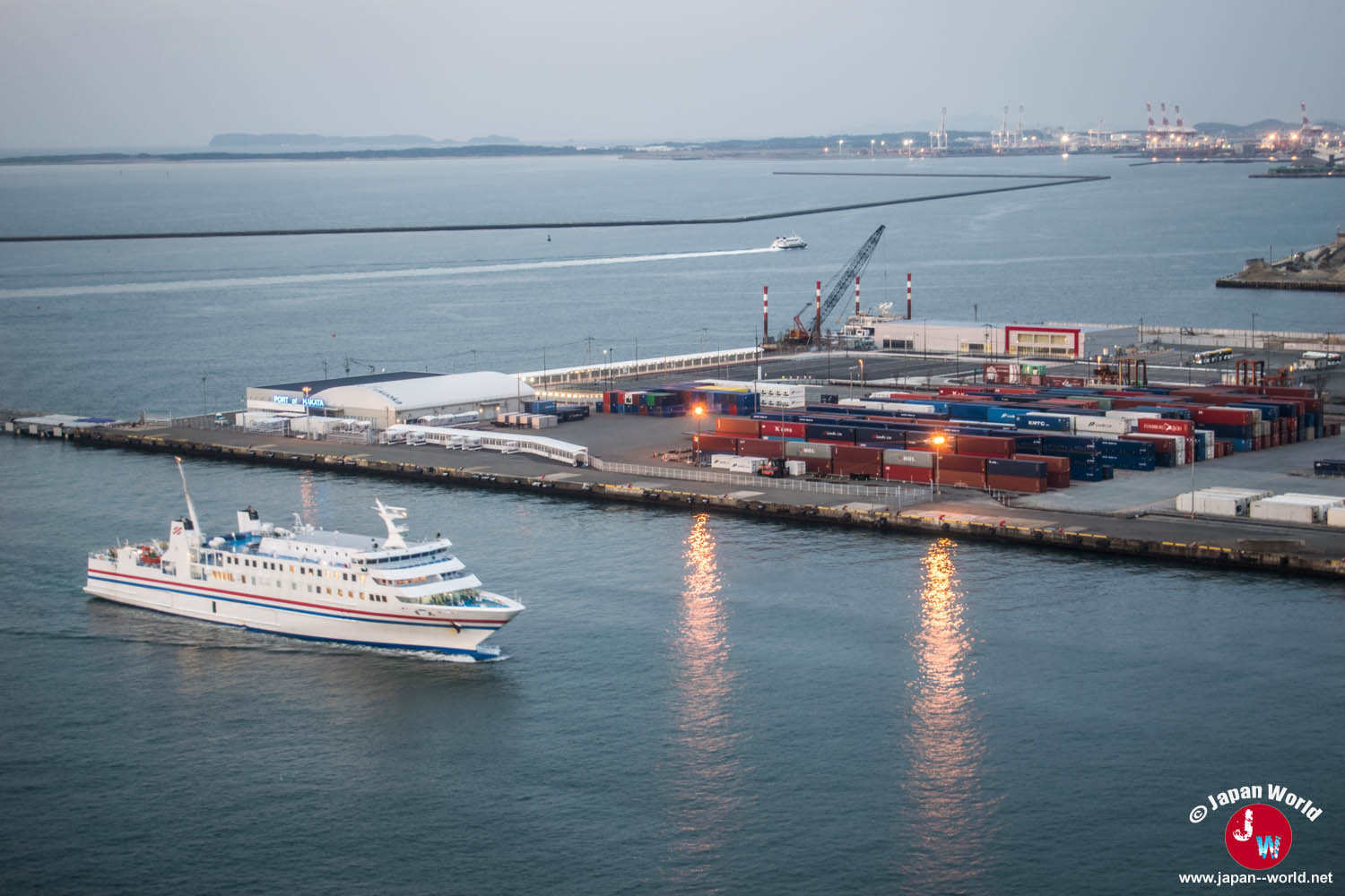 Ferry quittant le terminal du port de Hakata devant les quais et les conteneurs
