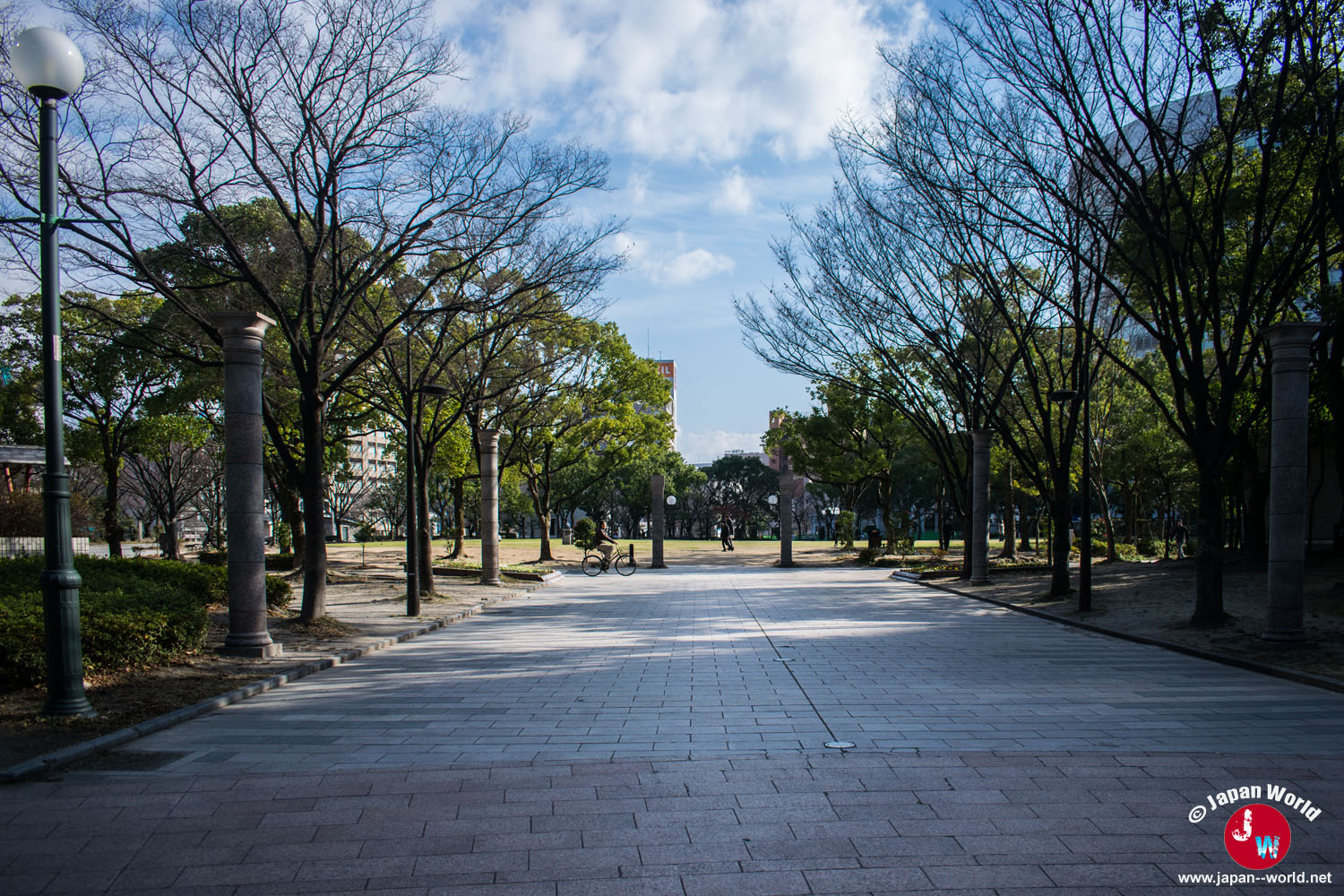 Allée principale bordée d'arbres et de colonnes au Tenjin Central Park