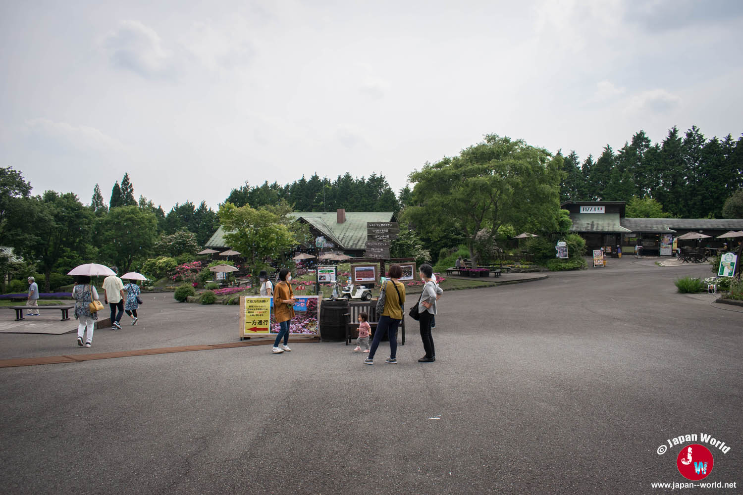 Allée d'entrée du Kuju Flower Park avec des visiteurs et des bâtiments