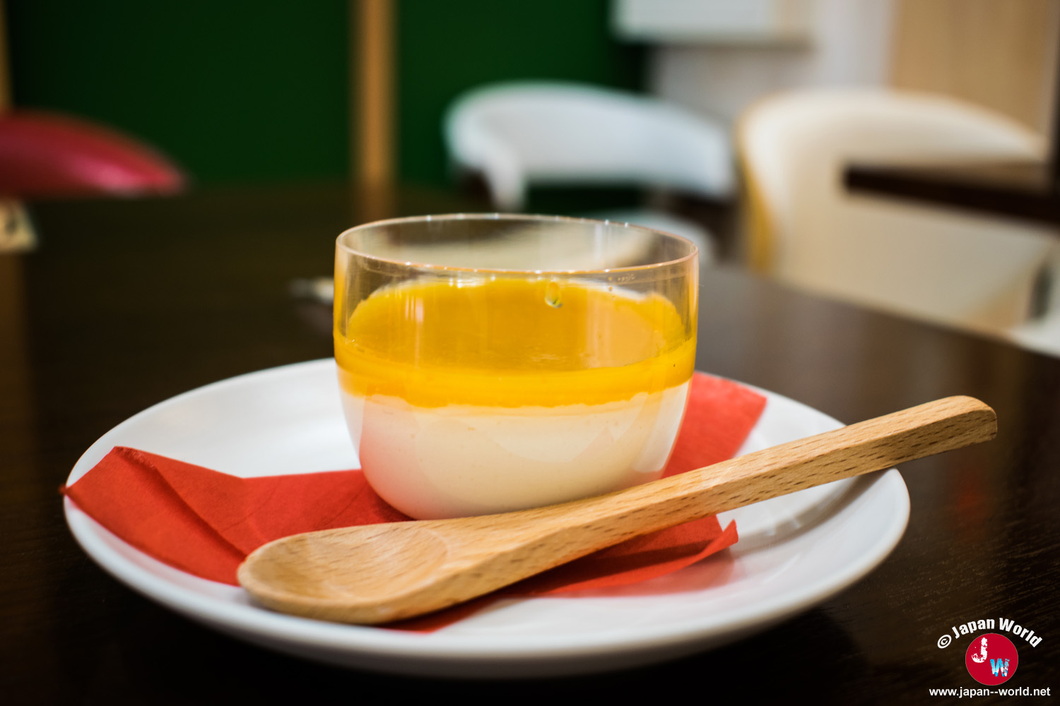 Dessert en verrine nappé d'un coulis orange et présenté avec une cuillère en bois au RotaCafe