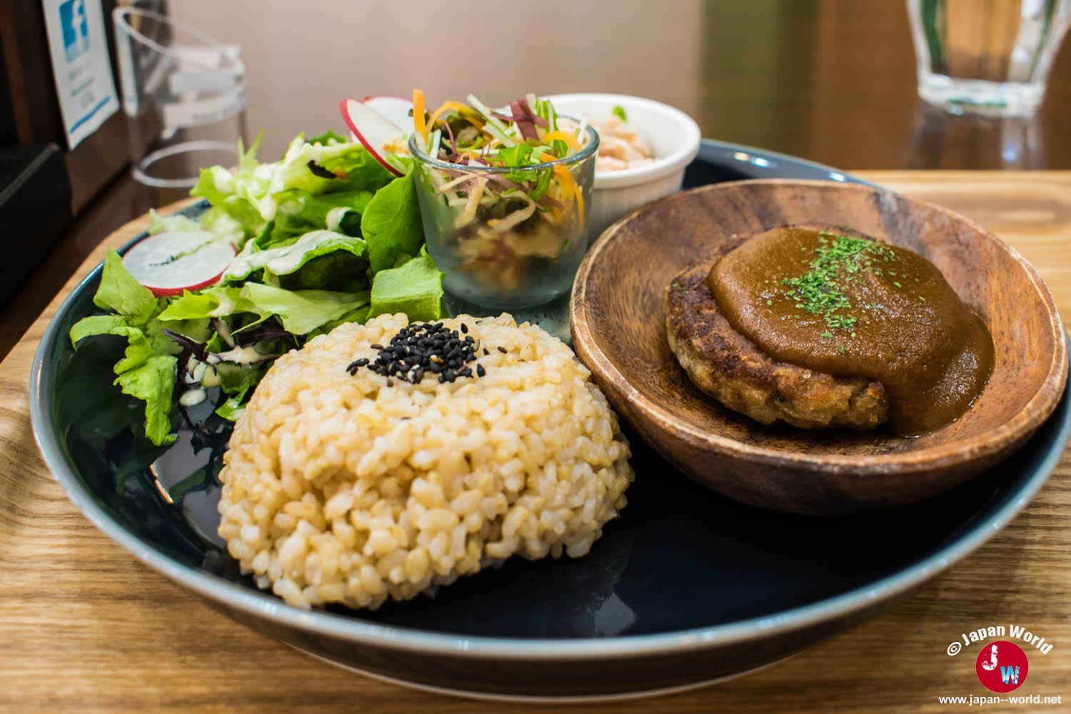 Assiette végétarienne avec riz complet, salade et galette nappée de sauce brune au RotaCafe
