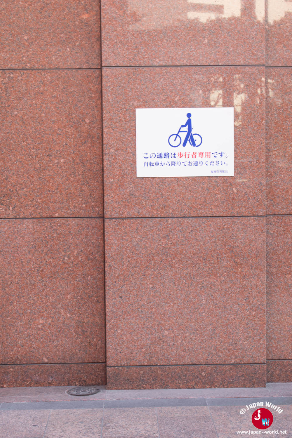 Panneau demandant aux cyclistes de descendre de leur vélo dans un passage réservé aux piétons