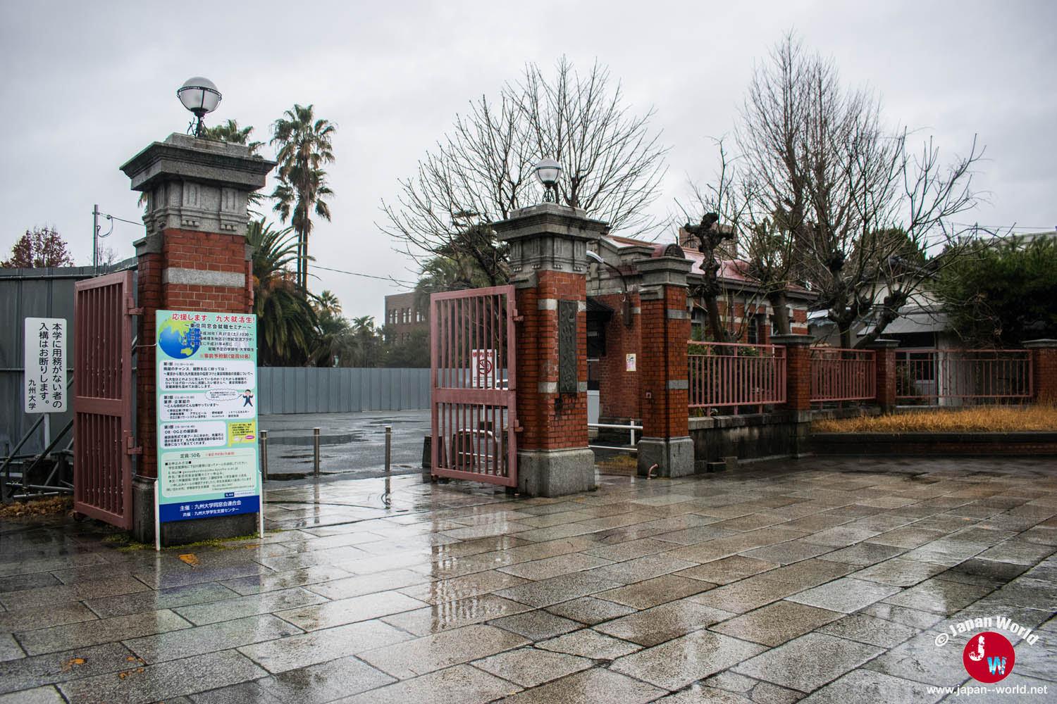 Entrée du campus Hakozaki de l'université de Kyushu sous la pluie, avec son portail en briques