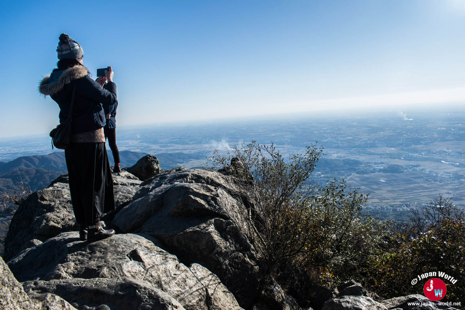 Randonneur debout sur les rochers du pic Nyotai