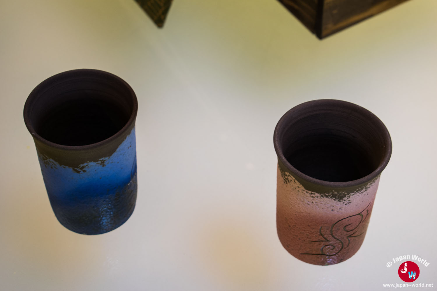 Deux hauts gobelets en céramique bleue et rose présentés dans la boutique Ishikura